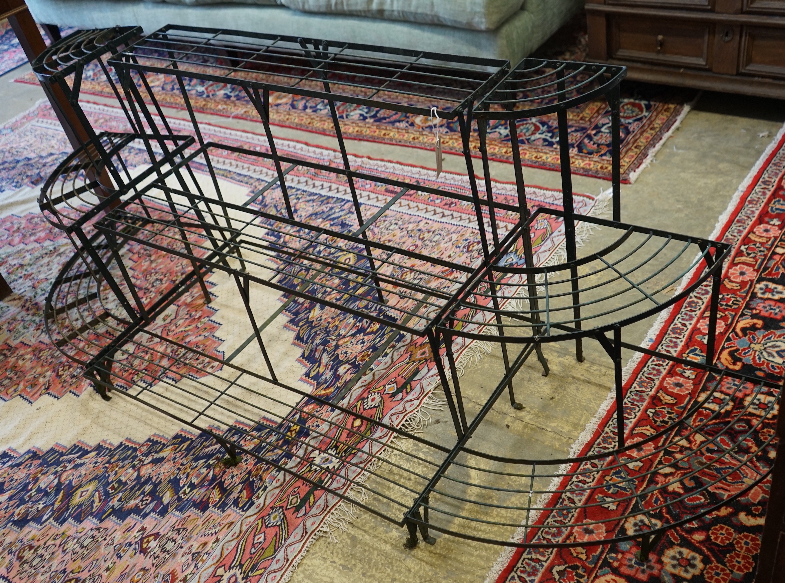 A Victorian style painted wrought iron framed three section pot stand, width 218cm, depth 60cm, height 75cm